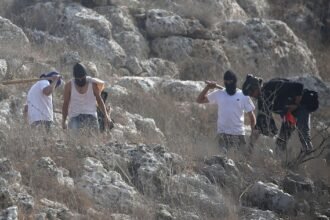 مستوطنون غير شرعيين، يغطون وجوههم بأقنعة