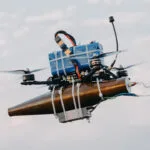 A lightweight drone with an RPG warhead strapped to it using cable-ties