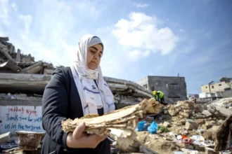 اليونسكو حنين العماسي تجمع المواد الوثائقية من أنقاض موقع دمر في غارة جوية في غزة