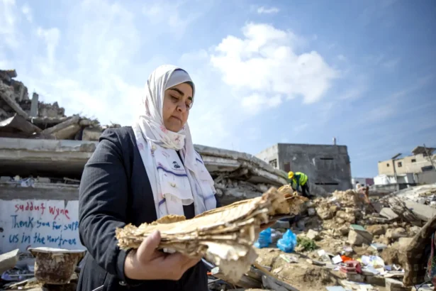 اليونسكو حنين العماسي تجمع المواد الوثائقية من أنقاض موقع دمر في غارة جوية في غزة